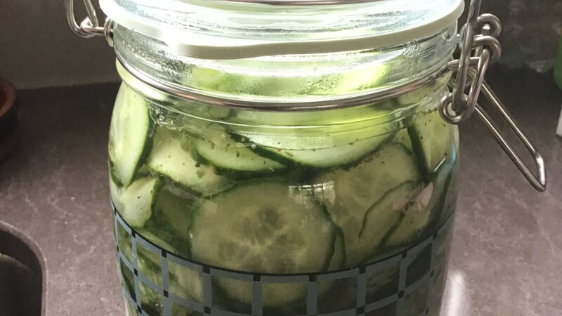 Ingelegde zoetzure komkommer met lente-uitjes en peterselie