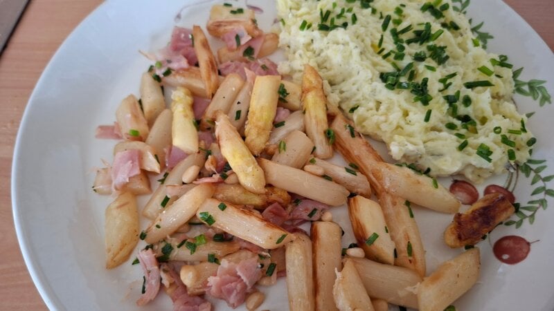 Gekarameliseerde witte asperges met ham, kaas en pijnboompitten
