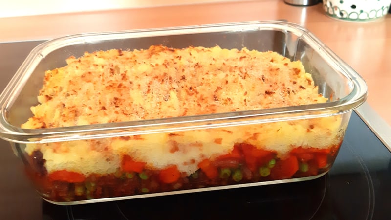 Indische gehaktschotel met wortel, doperwten en gekruide aardappelpuree