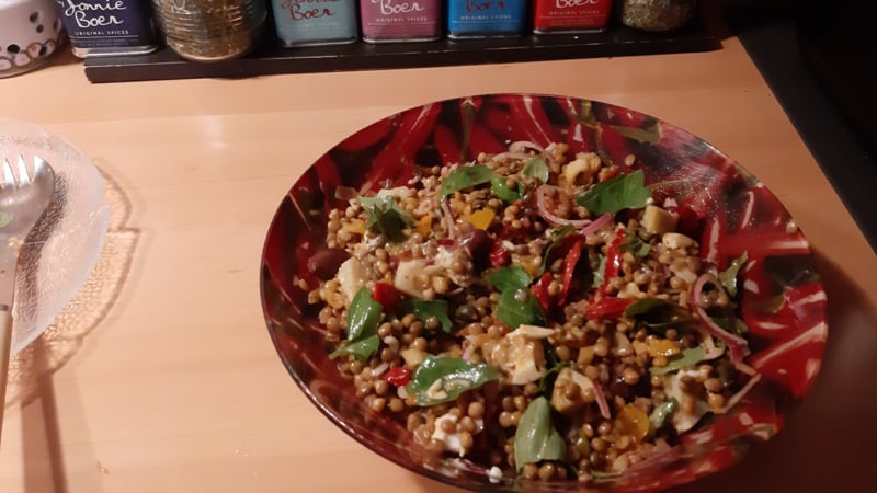 Italiaanse linzensalade met artisjokharten, gedroogde tomaten, gele mini tomaten, geitenkaas en basilicum