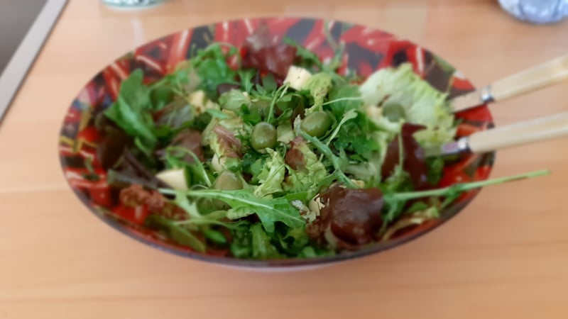 Gemengde rucola salade met witte kaasblokjes, gedroogde tomaten en olijven