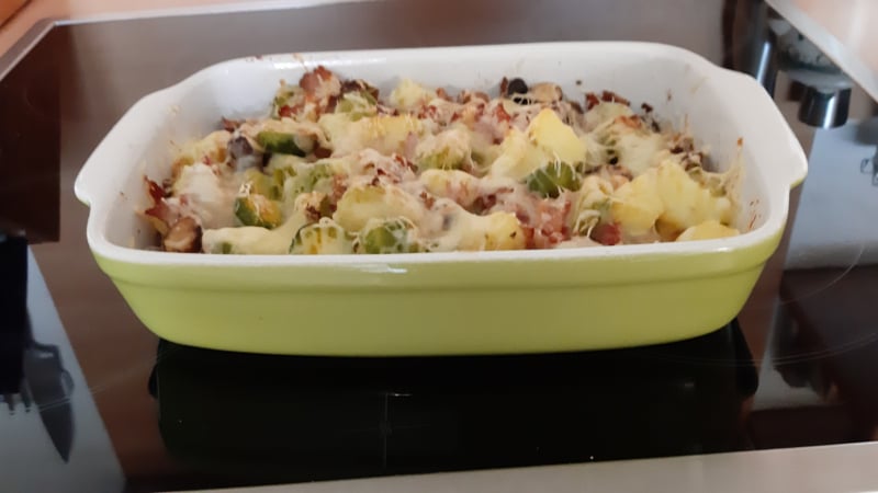 Spruitjesschotel met aardappelblokjes, pancetta, champignons en kaas