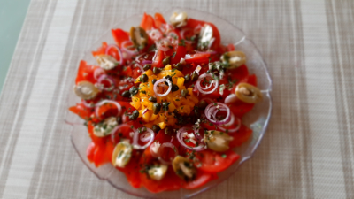 Spaanse tomaten/paprikasalade met rode ui, kappertjes en gevulde olijven