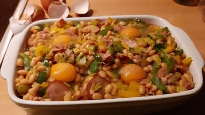 Engelse witte bonenschotel met rookworst, eieren, prei en paprika