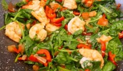 Aziatische wok met grote garnalen, spinazie en paprika