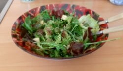 Gemengde rucola salade met witte kaasblokjes, gedroogde tomaten en olijven