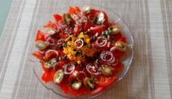Spaanse tomaten/paprikasalade met rode ui, kappertjes en gevulde olijven